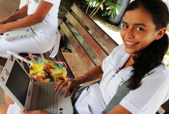 Un niña sonriente con un ordenador portátil